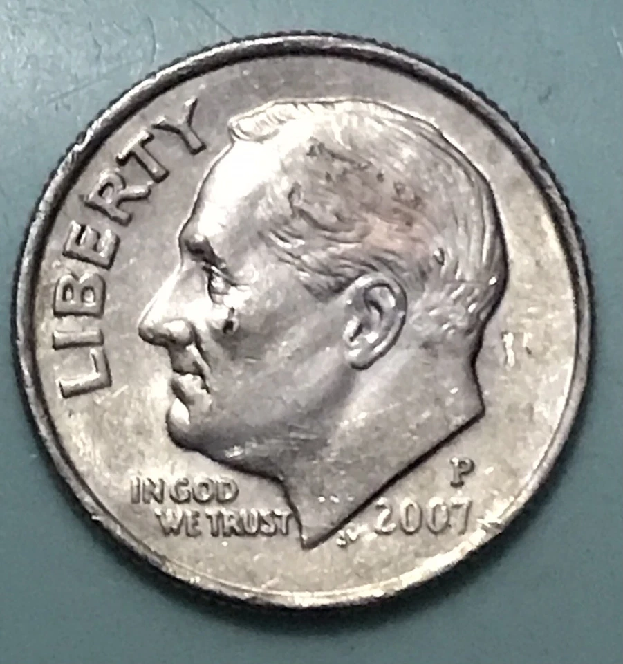 2007 Roosevelt dime design struck on a Lincoln cent planchet showing the copper-colored smaller blank with dime design